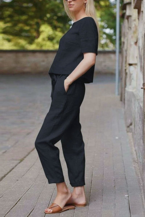 Relaxed black cotton linen set with short-sleeve top and straight-leg pants, breathable and lightweight for all-day comfort.