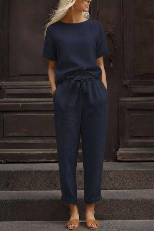 Woman wearing navy blue relaxed cotton linen set with short-sleeve top and drawstring pants