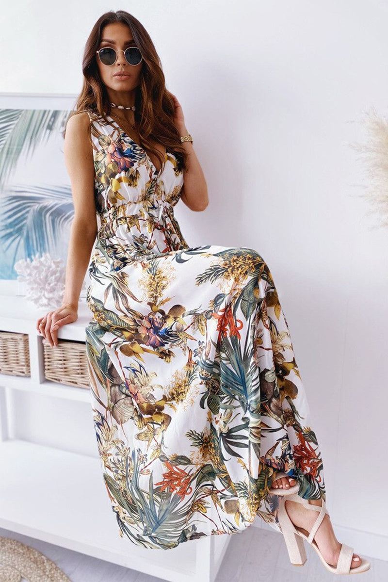 Woman wearing a colorful floral casual sleeveless dress with sunglasses and heels sitting indoors
