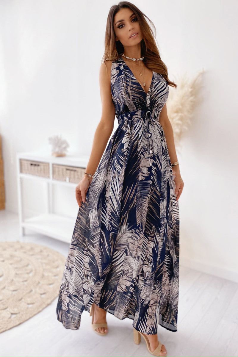 Woman wearing a casual sleeveless print strap dress with a flowy design and leaf pattern