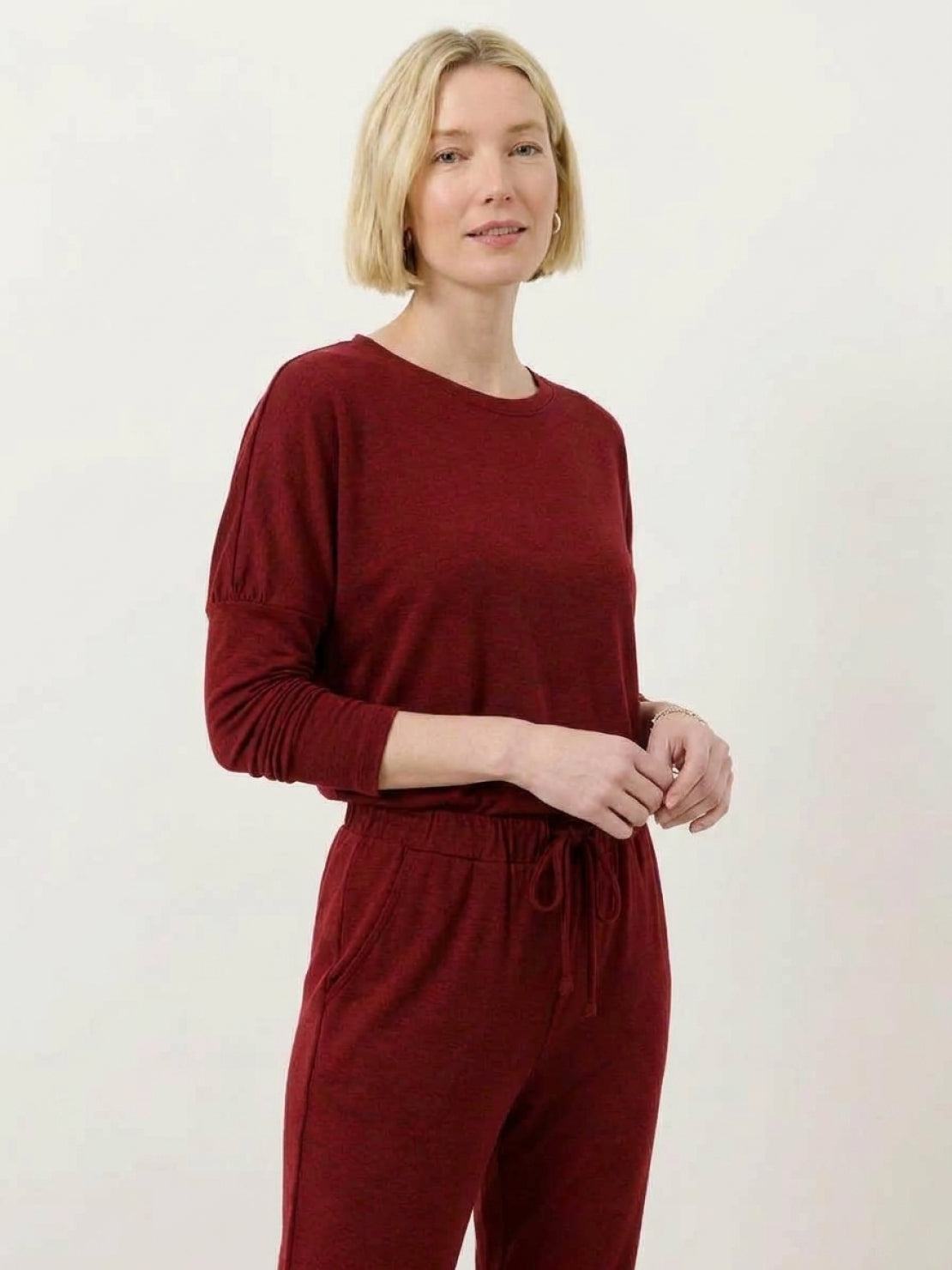 woman wearing Cozy Chic Two-Piece Sweatsuit Set with long-sleeve top and high-waisted pants with pockets in neutral tones