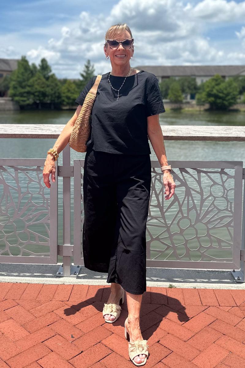 woman wearing black loose fit co-ord set with short sleeves and wide-leg pants outdoors