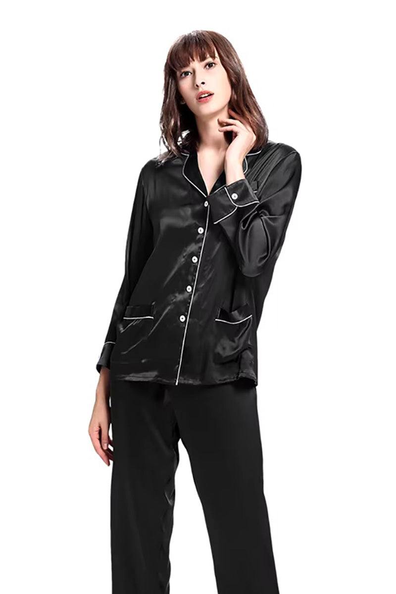 Woman wearing black long sleeve silk pajamas with button-up top and matching pants