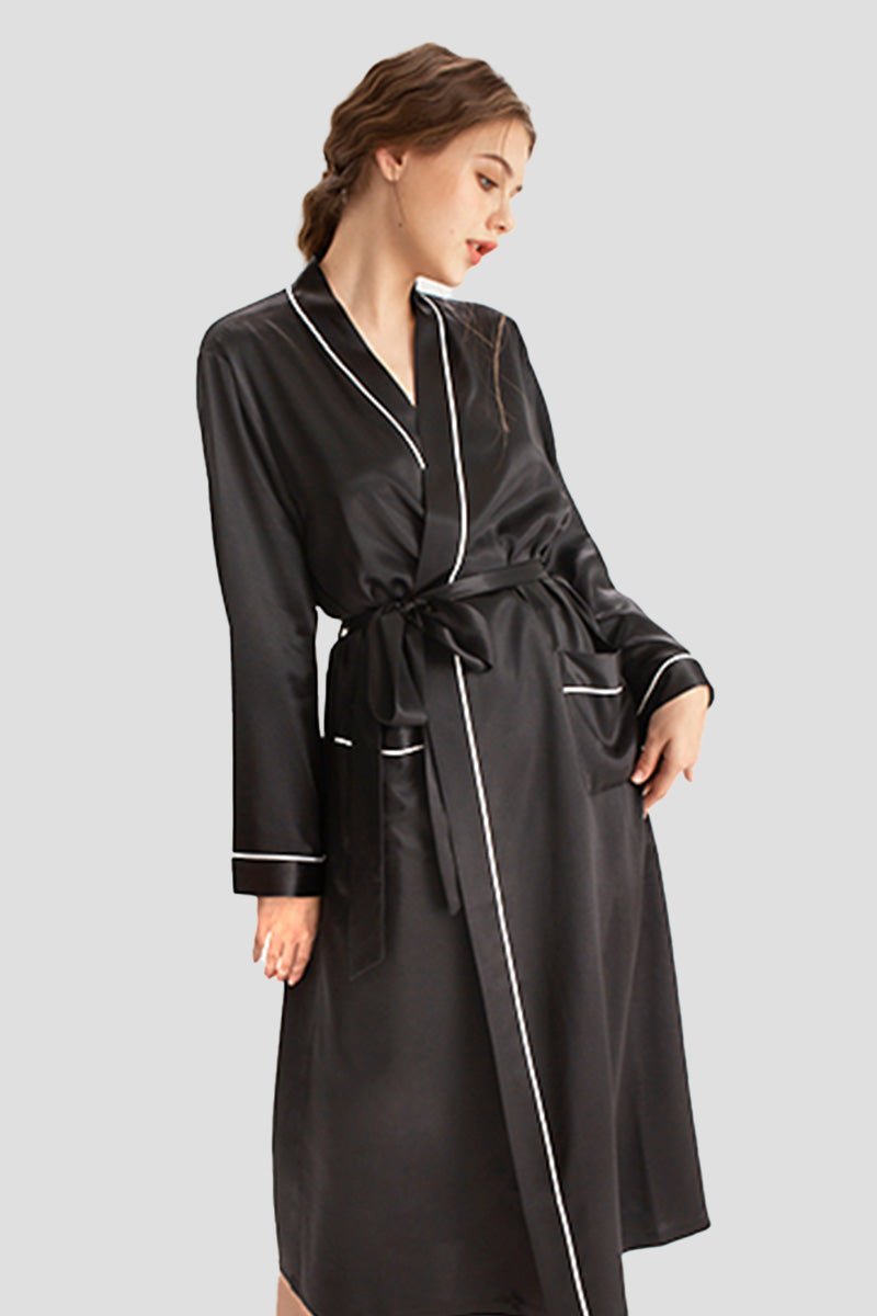 Woman wearing a black 100% mulberry silk belted classy nightgown with white trim and long sleeves