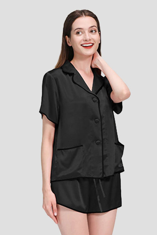 Woman wearing black 100% mulberry silk hemd trimmed short-sleeve pajama set with shorts