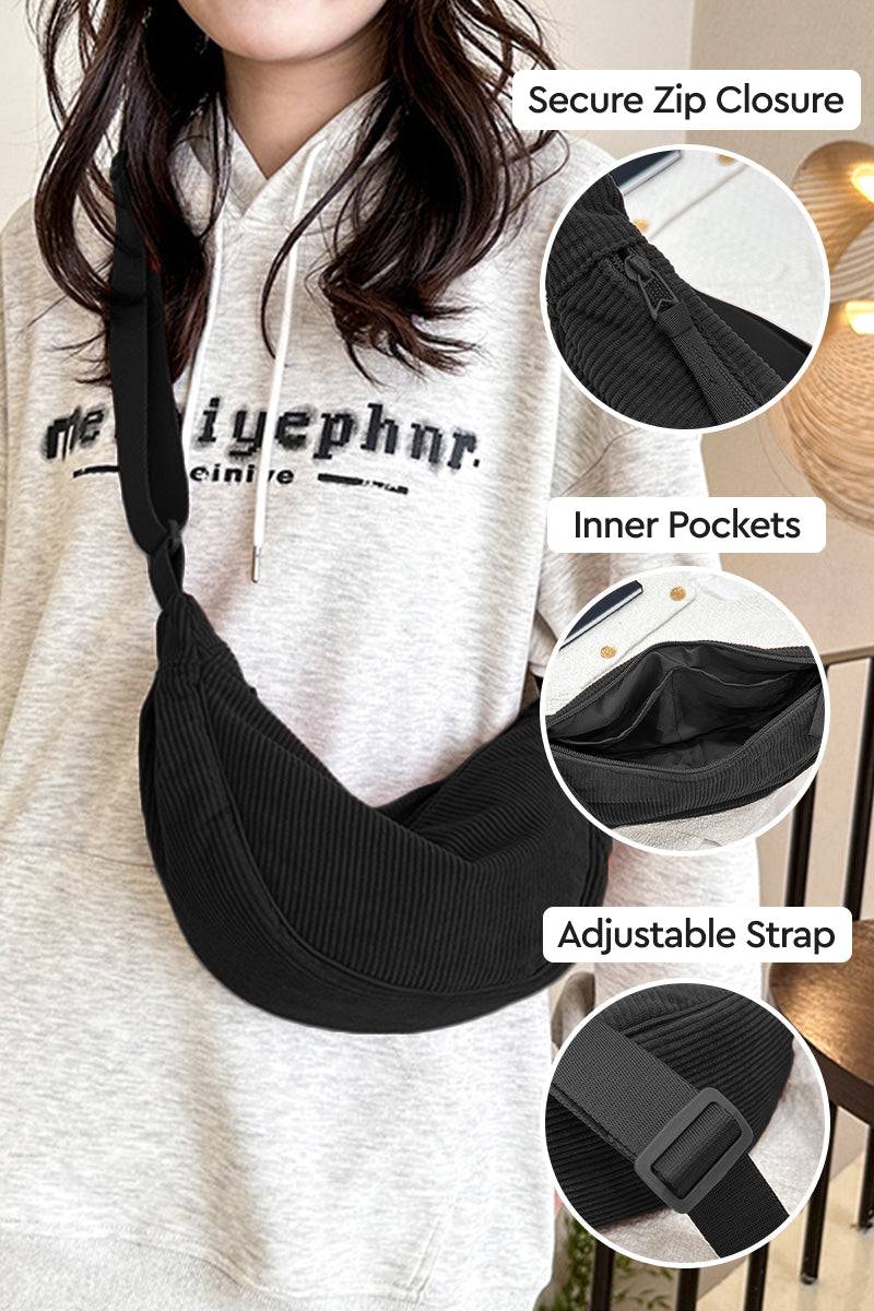 Black corduroy shoulder bag with adjustable strap, secure zip closure, and inner pockets worn crossbody on person