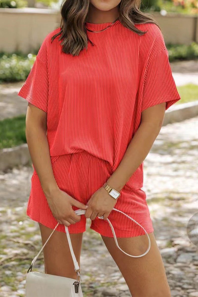Woman wearing red short sleeve relaxed fit top and matching shorts set for slow mornings outdoors
