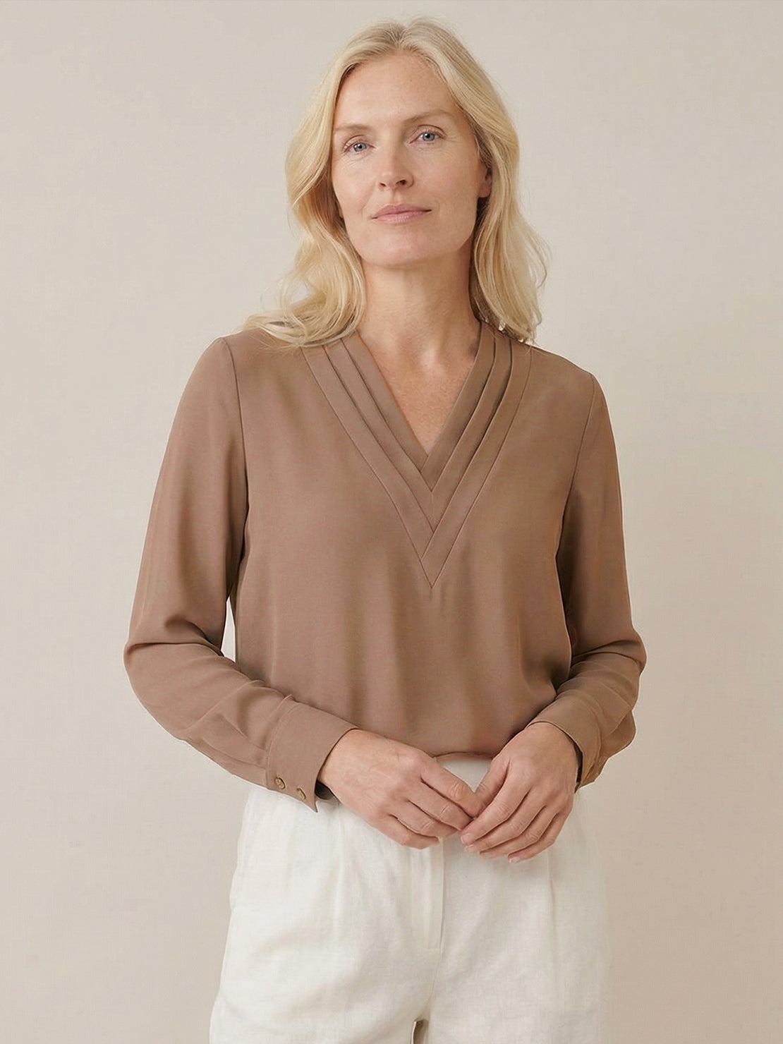 White pleated V-neck long-sleeve blouse with diagonal panel and button cuffs