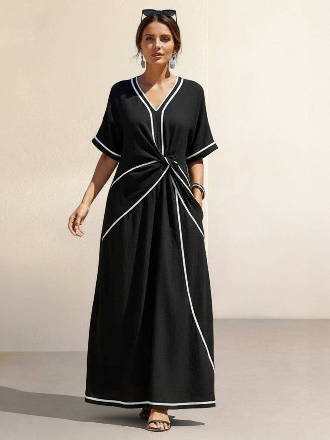 Knot-waist maxi dress with twist-knot detail, V-neckline, batwing sleeves, flowing skirt, and side pockets.
