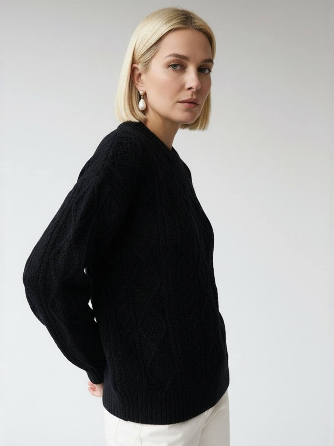 Oversized cable-knit crewneck sweater with dropped shoulders and deep textured pattern