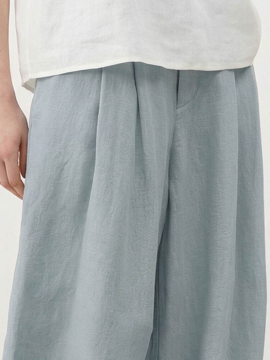 White Tencel-linen pleated wide-leg pants with hook-and-zipper waist closure and floor-skimming silhouette