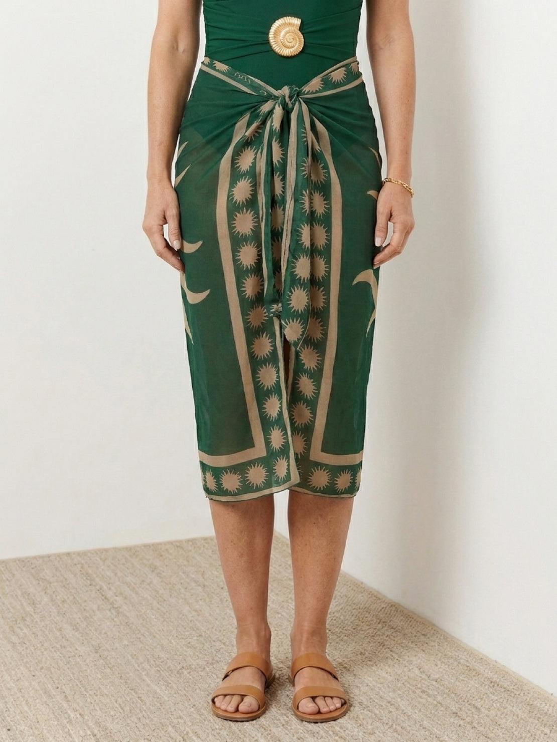 Deep-V swimsuit with ruched bust and waist, wide straps, low open back, and sheer celestial print sarong tied at hip