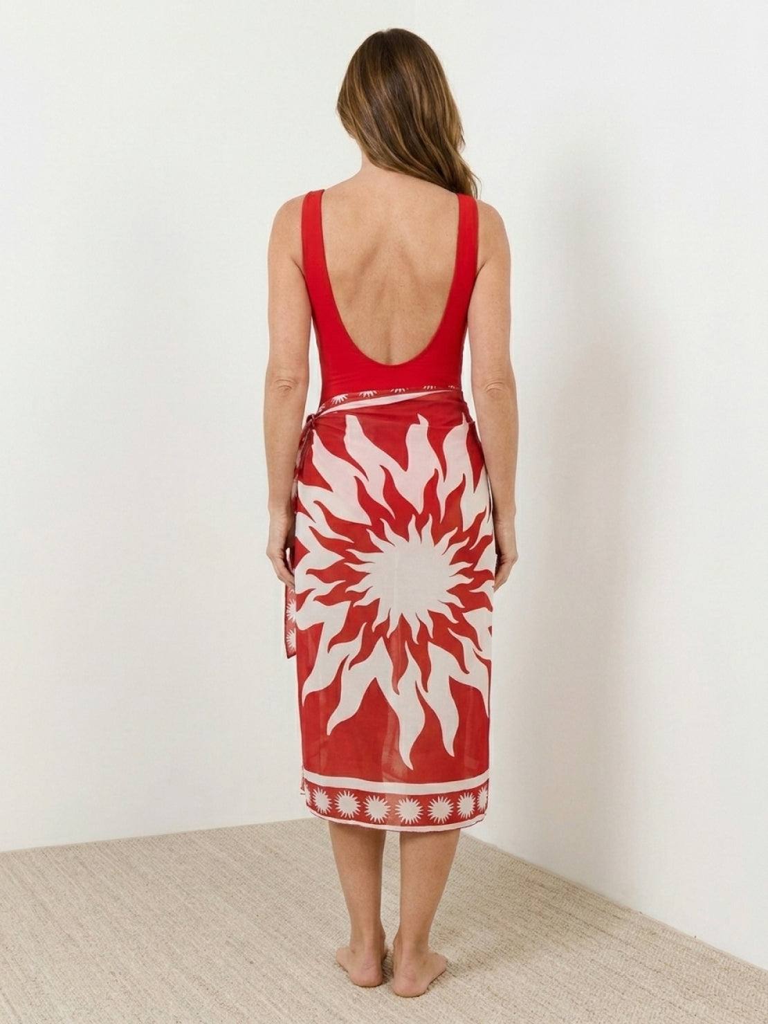 Deep-V swimsuit with ruched bust and waist, wide straps, low back, gold shell detail, and sheer celestial print sarong wrap