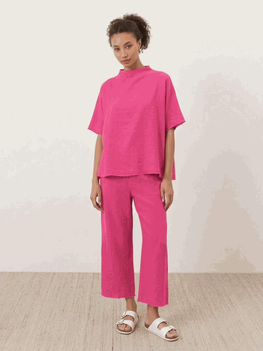 Woman wearing cotton-blend capelet top with batwing sleeves and wide-leg cropped pants lounge set in chocolate brown