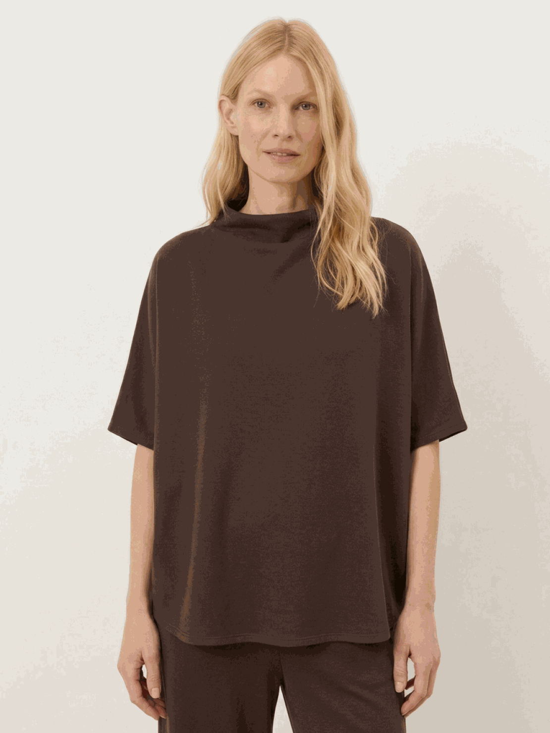 Woman wearing a cotton-blend capelet top with batwing sleeves and wide-leg pants lounge set