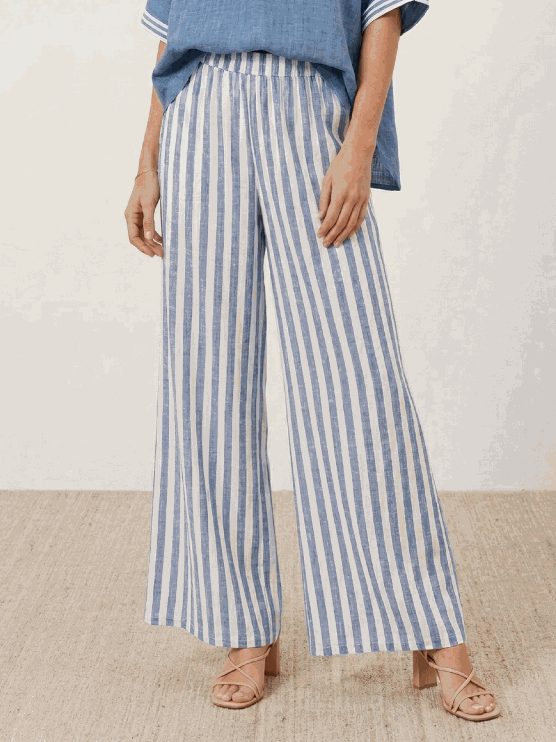 Woman wearing black striped wide-leg co-ord set with oversized top and palazzo pants with elastic waist and side pockets