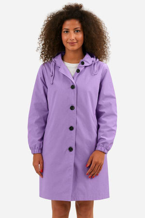 Woman wearing a purple water-resistant oversized hooded windbreaker rain jacket