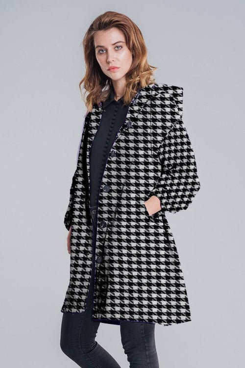 Woman wearing a black and white water-resistant oversized windbreaker rain jacket with houndstooth pattern