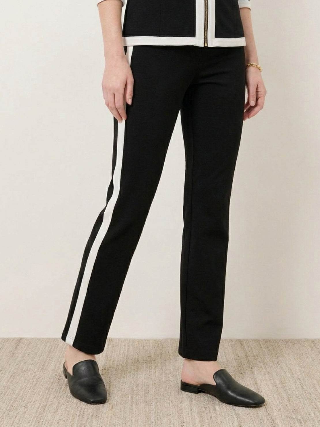 Woman wearing sleek contrast zip two-piece outfit in black and camel colors