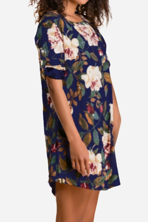 Woman wearing all over floral print linen shift dress in navy blue with rolled-up sleeves