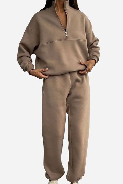 Woman wearing a Classic Airplane Set two-piece cozy brown tracksuit with a high collar and zipper pullover and jogger pants.