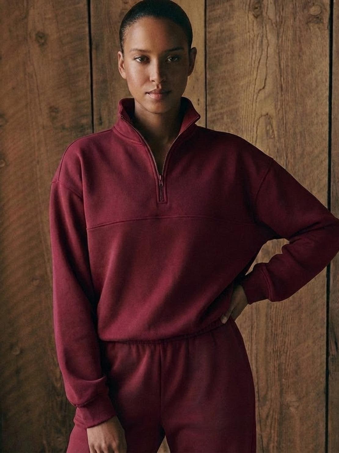 Woman wearing a comfortable cotton-blended two-piece tracksuit with high collar and deep zipper, styled for casual confidence and athleisure look
