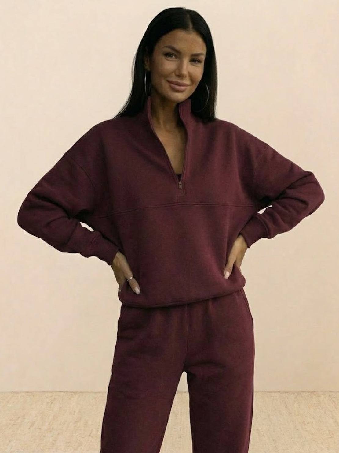 Woman wearing a cotton-blended two-piece tracksuit with high collar and deep zipper, showcasing athleisure comfort and style.