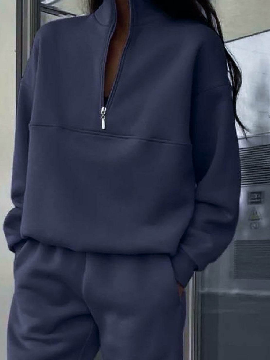 woman wearing gray cotton-blended two-piece tracksuit with high collar and deep zipper outdoors