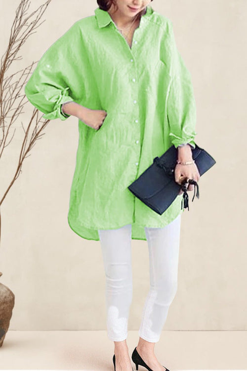 Oversized linen shirt in light green with loose sleeves and button front, styled with white pants and black clutch.
