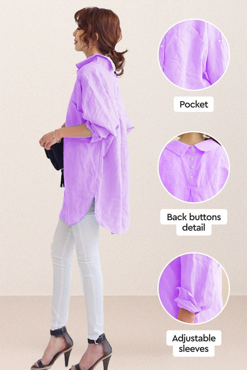 Woman wearing oversized linen shirt in lavender with back buttons, adjustable sleeves, and pocket details, styled with white pants and black heels