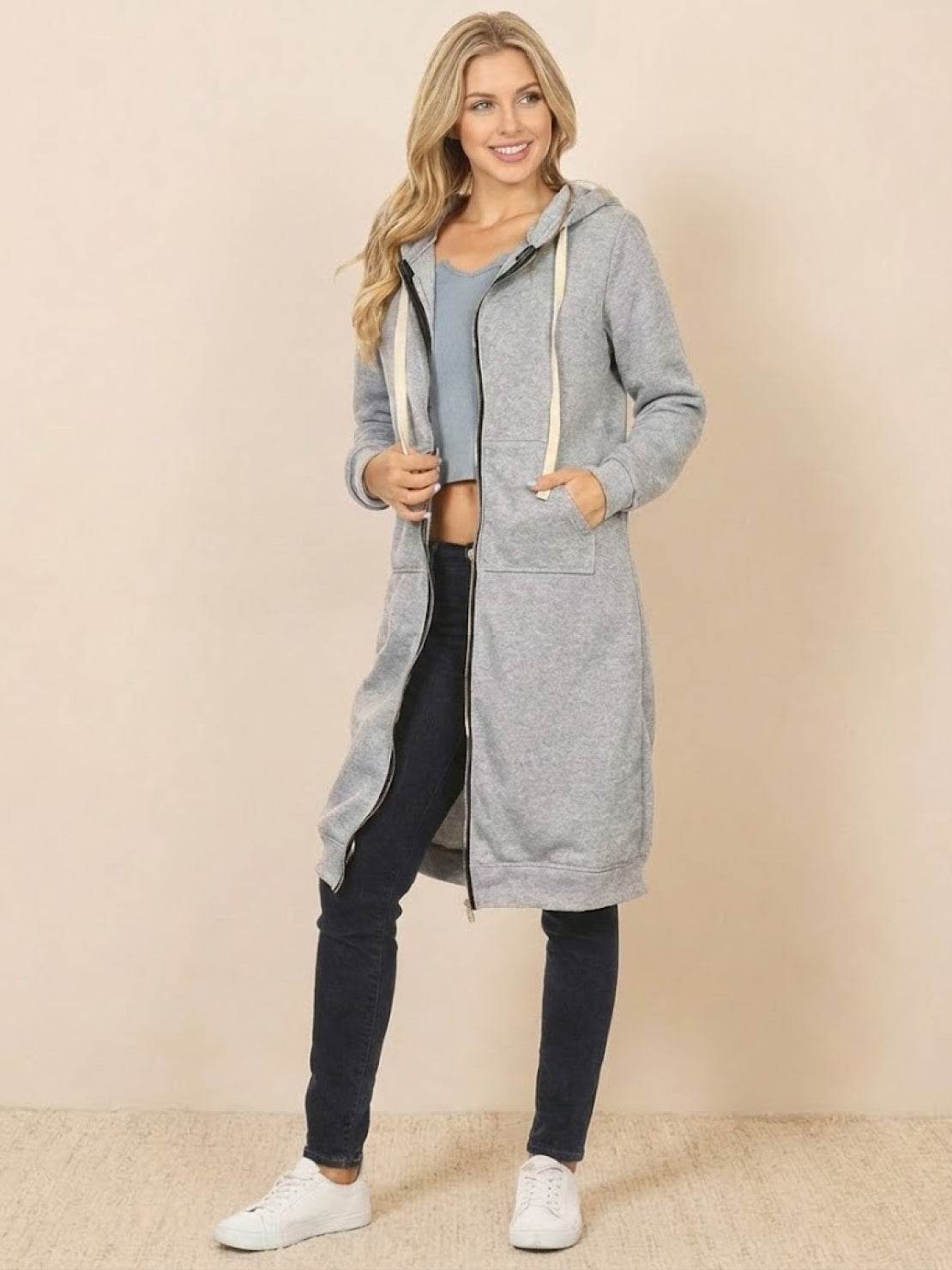 woman wearing gray oversized long zip sweatshirt hoodie with front pockets and drawstring hood