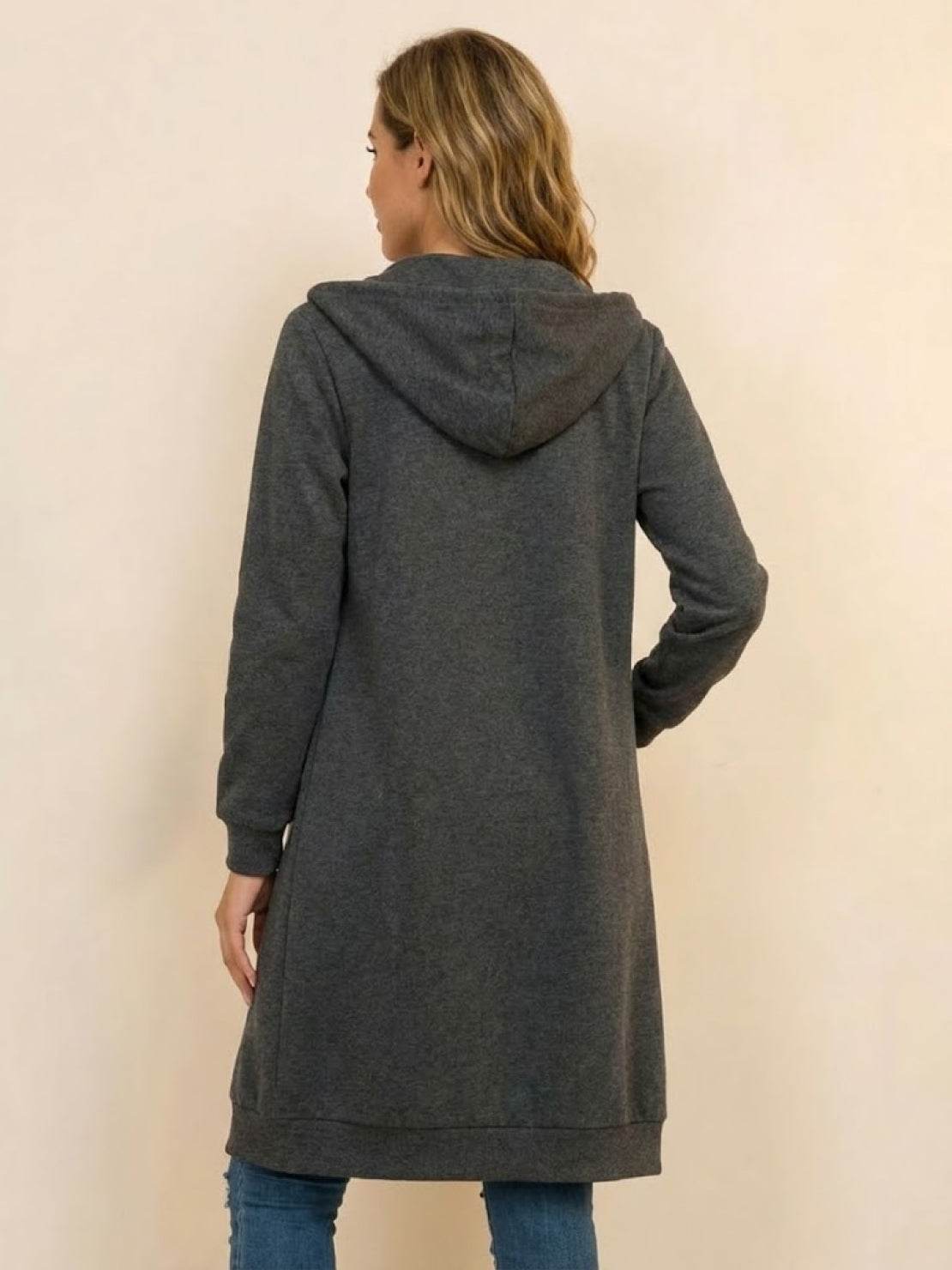 Back view of a woman wearing a dark gray oversized long zip sweatshirt hoodie with hood, perfect for layering and warmth