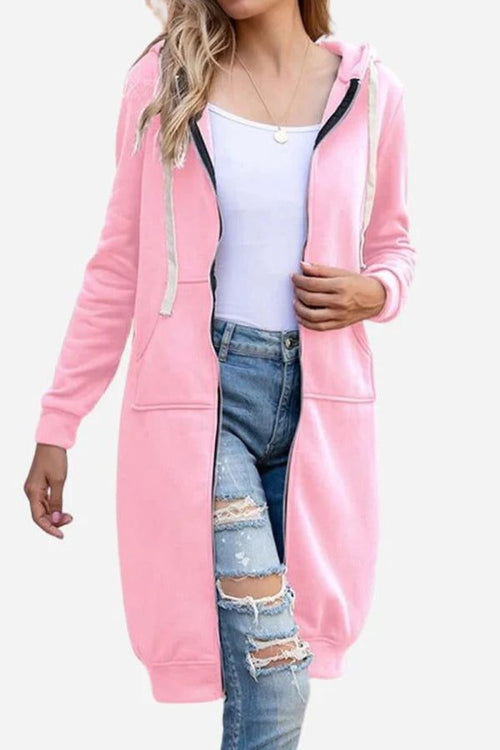 Pink oversized long zip sweatshirt hoodie with drawstring hood and front pockets worn over white tank top and ripped jeans