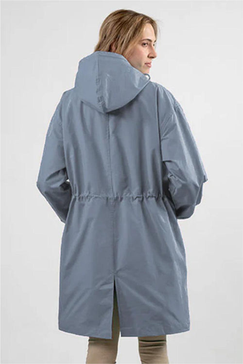 Back view of woman wearing oversized blue Rain Couture Windbreaker with hood and adjustable waist