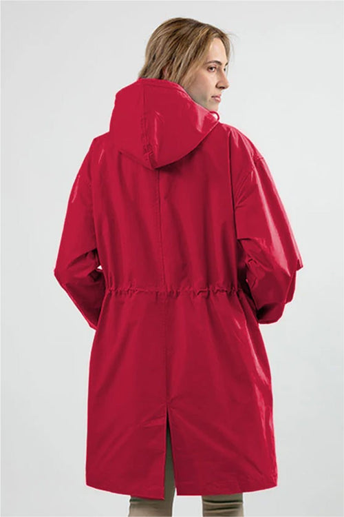 Woman wearing oversized red Rain Couture Windbreaker water-resistant jacket with hood, back view