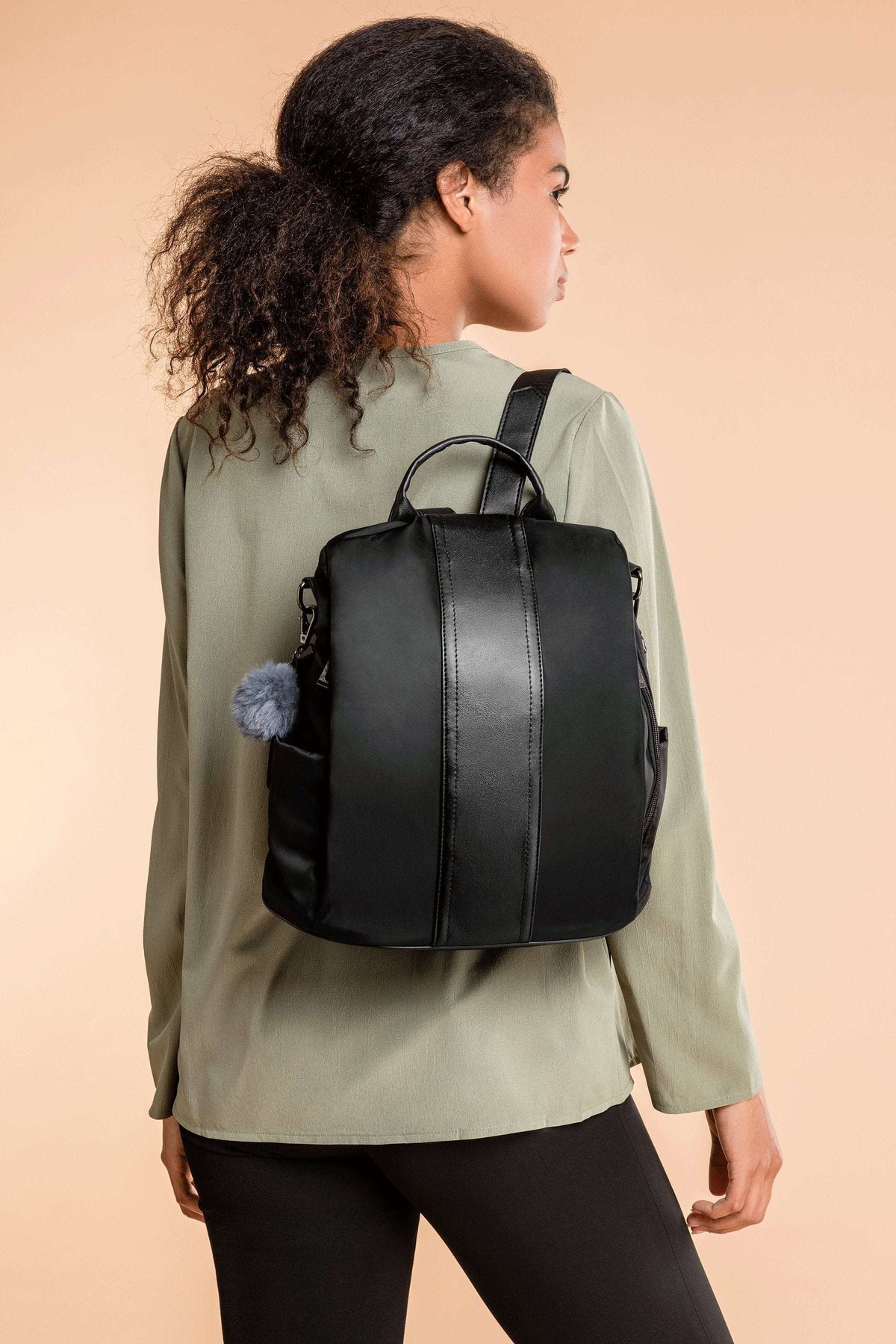 Woman wearing black anti theft waterproof fashion backpack with adjustable straps and multiple compartments
