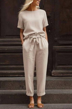 Woman wearing beige cotton linen set with short-sleeve top and straight-leg pants with drawstring waist