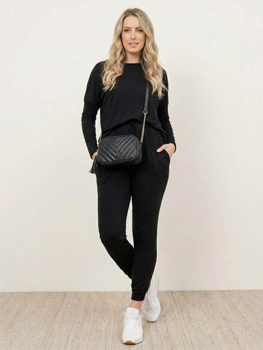 Woman wearing Cozy Chic Two-Piece Sweatsuit Set with long-sleeve top and high-waisted pants with pockets