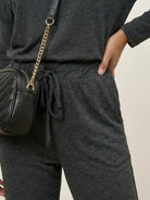 woman wearing cozy chic two-piece sweatsuit set with long-sleeve top and high-waisted pants
