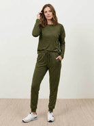 woman wearing cozy chic two-piece sweatsuit with long-sleeve top and high-waisted pants with pockets for travel and casual wear