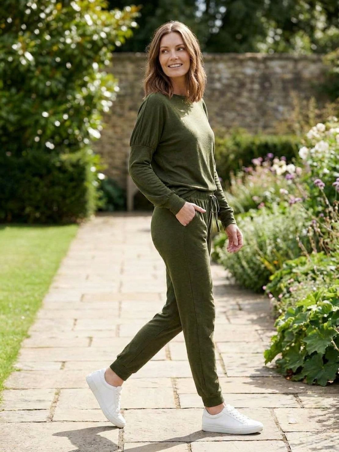 woman wearing Cozy Chic Two-Piece Sweatsuit Set with long-sleeve top and high-waisted pants with pockets in casual indoor setting