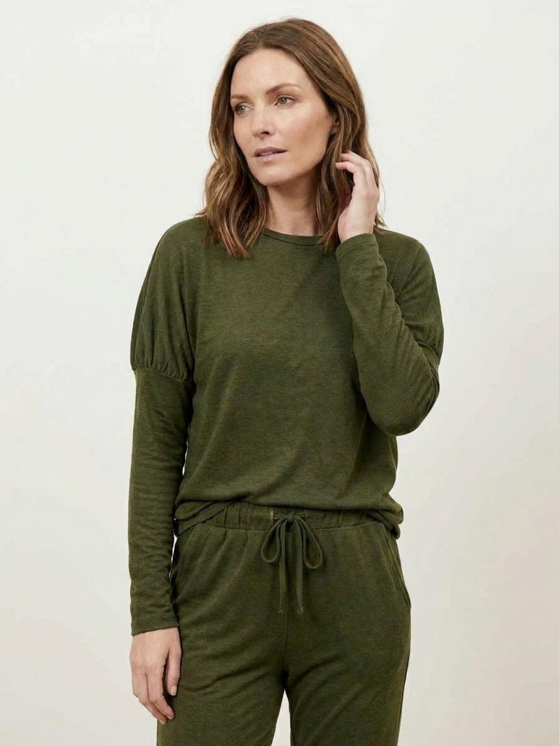 woman wearing cozy chic two-piece sweatsuit set with long-sleeve top and high-waisted pants with pockets