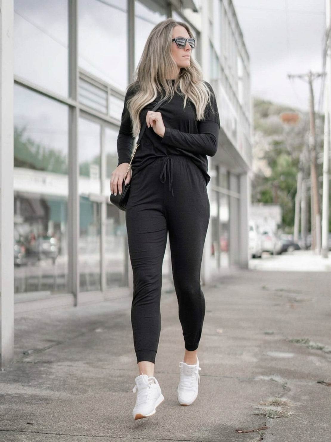 woman wearing cozy chic two-piece sweatsuit set with long-sleeve top and high-waisted pants with pockets