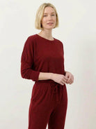 woman wearing Cozy Chic Two-Piece Sweatsuit Set with long-sleeve top and high-waisted pants with pockets in neutral tones