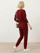 woman wearing cozy chic two-piece sweatsuit set with long-sleeve top and high-waisted pants with pockets