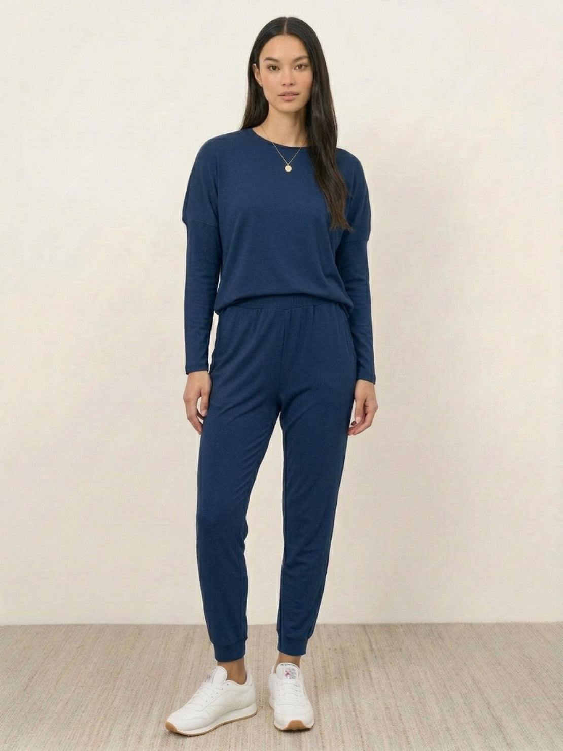 woman wearing Cozy Chic Two-Piece Sweatsuit set with long-sleeve top and high-waisted pants with pockets