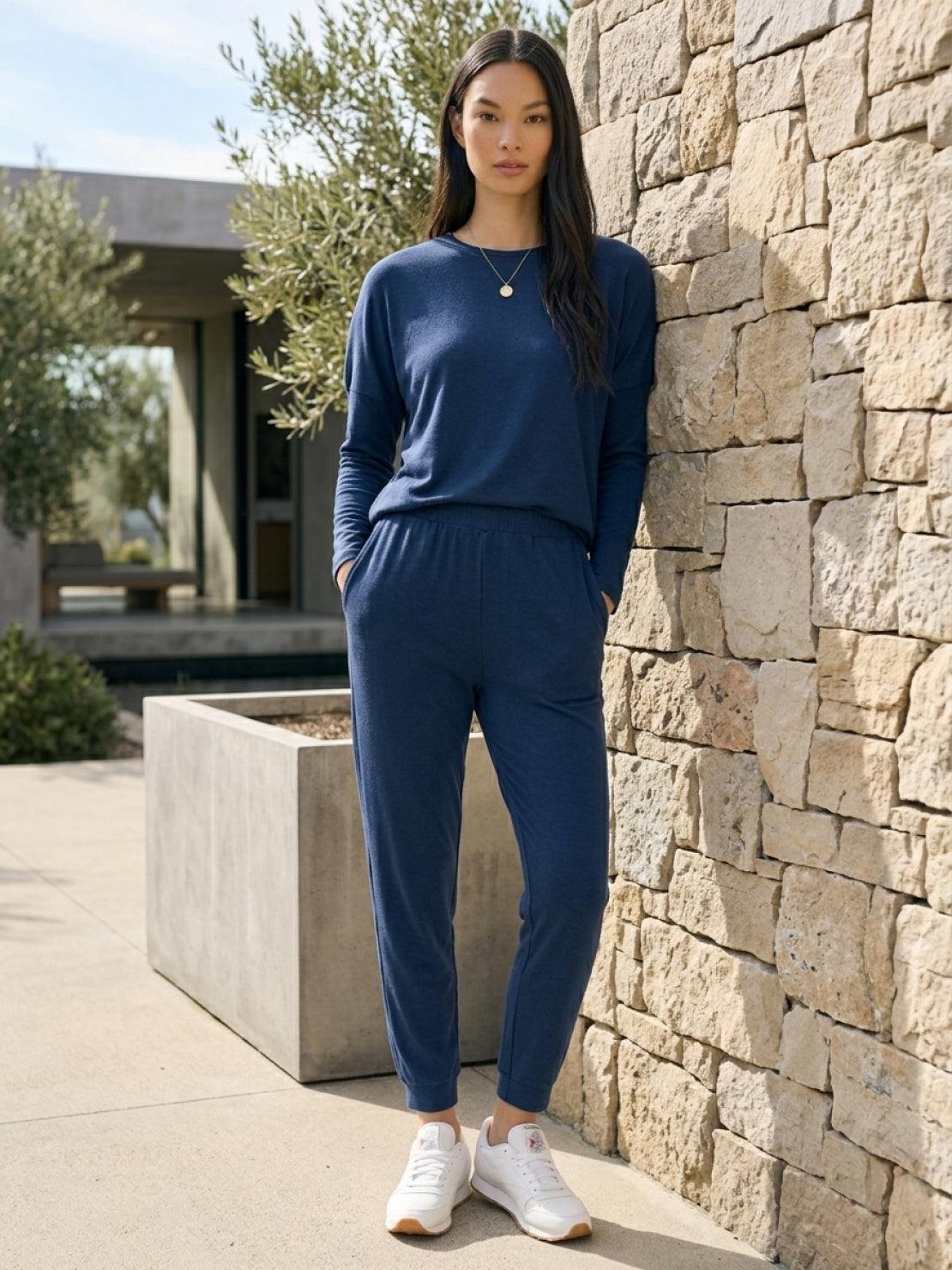 woman wearing Cozy Chic Two-Piece Sweatsuit set with long-sleeve top and high-waisted pants with pockets, styled for casual comfort and travel