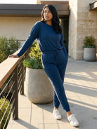 woman wearing cozy chic two-piece sweatsuit set with long-sleeve top and high-waisted pants with pockets