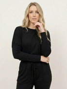 woman wearing cozy chic two-piece sweatsuit set with long-sleeve top and high-waisted pants with pockets