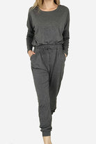 Woman modeling cozy chic two-piece sweatsuit set with long-sleeve top and high-waisted pants with pockets